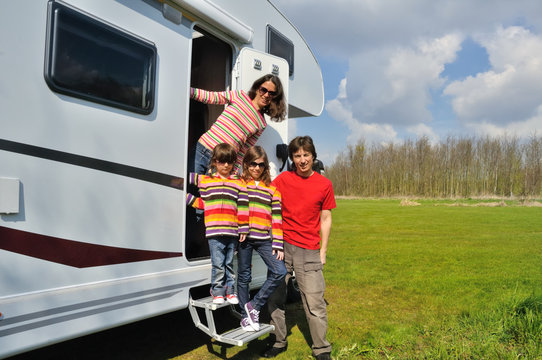 Family vacation, RV travel with kids, happy parents with children on holiday trip in motorhome, camper exterior
