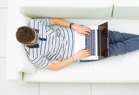 Man Relaxing on Sofa with Laptop Computer