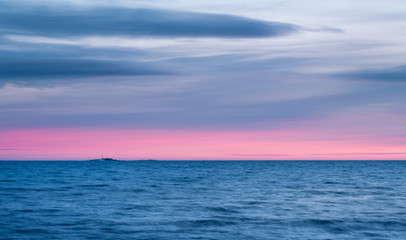 Seascape with sunset and pink horizon at winter evening
