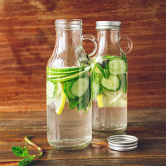 Light, refreshing drink of lime, lemon and cucumber in small glass bottles