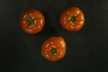 Background food ingredients on black table. Fresh tomatoes,
