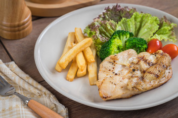 Grilled chicken steak and french fries on plate