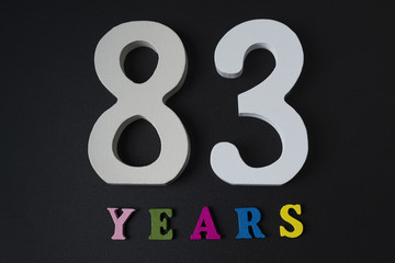 Letters and numbers eighty-three years old on a black background.