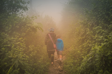 Boy and woman walking in the mist