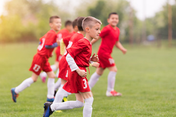 Obraz na płótnie Canvas Kids soccer football - children players exercising before match on soccer field