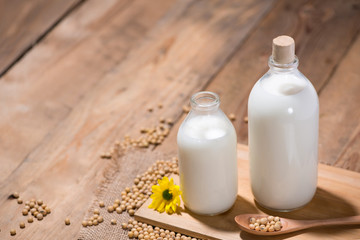 Soy milk or soya milk and soy beans in spoon on wooden table.
