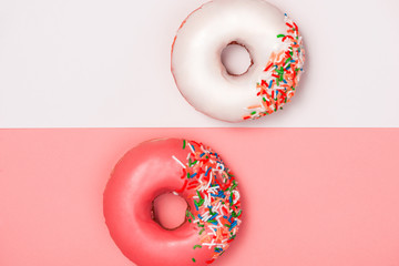 Donuts with icing on colorblock background. Sweet donuts.