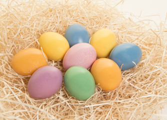 Fototapeta na wymiar Colored easter eggs lying in a nest on a white background