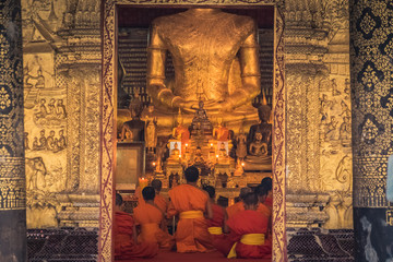 Monks during prayers in a temple in Luang Pranbang, Laos