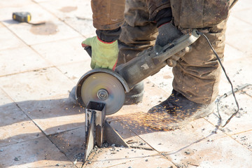 Worker cuts metal in the park