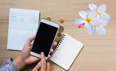 Coins and flower on book bank account for money saving concept