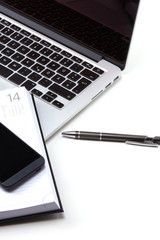 Flat lay home office workspace with laptop, diary,  accessories on white background. Top view
