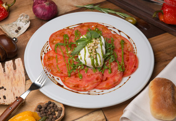 Serving Caprese salad on white plate in restaurant