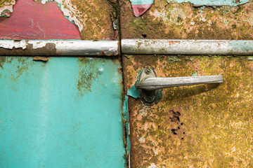 Close up of an antique old rusted  blue car door