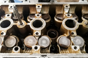 Worn uto car engine valves being serviced at garage