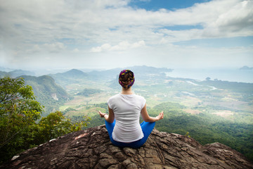 Young blonde woman practicing yoga and meditation in mountains during luxury yoga retreat in Bali, Asia