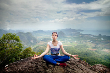 Fototapeta na wymiar Young blonde woman practicing yoga and meditation in mountains during luxury yoga retreat in Bali, Asia