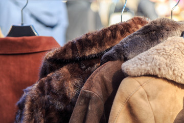 Vintage fur coats at a flea market in Europe. Used leather and suede clothing on garage sale or charity shop - 150902936