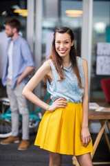 Obraz premium Portrait of smiling female executive standing with hands on hip