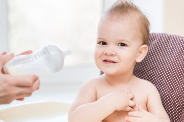 Mother feeds baby from a bottle of milk