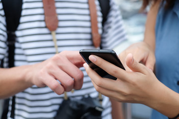 close up asian traveler woman hand pointing to smartphone touchscreen for helping tourism about travel map GPS  by using application on smart phone cellular mobile device.