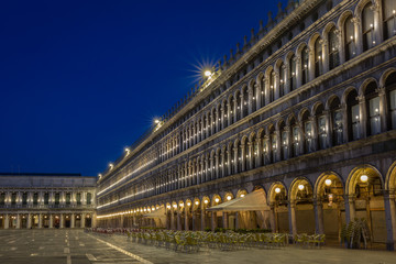 St Marks Square at Dawn showing lights on with no people and blues sky in the background.
