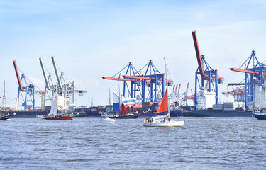 Hamburg harbor, birthday parade with various ships. View to Hamburg harbor with harbor cranes.