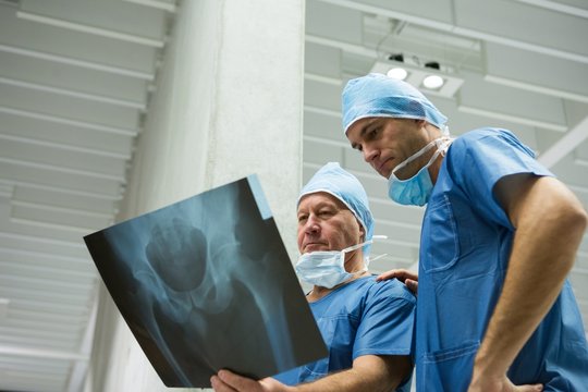 Male surgeons examining x-ray