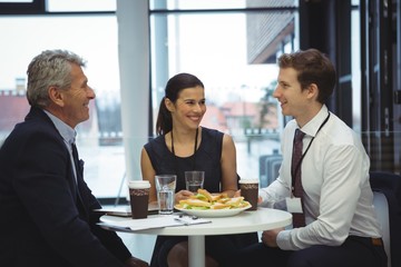 Businesspeople interacting while having breakfast