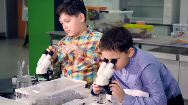 The school boys working in the science laboratory. Close-up. 4K.