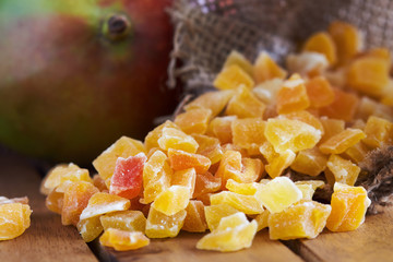 Closeup of dried and candied mango on wooden background
