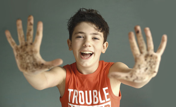 Mischievous Teen Boy With Dirty Hand Smile