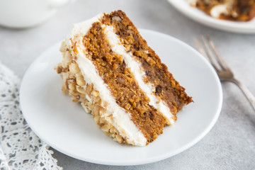 slice of delicious carrot cake with cream cheese frosting and nut