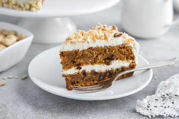 slice of carrot cake with cream cheese frosting and nuts