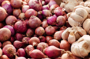 Red onion and garlic display on fresh market table for sale.