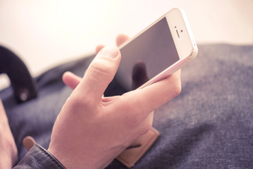 A man holding a mobile phone and texting in Airport
