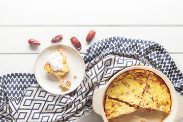 Casserole of cottage cheese with dates on a white wooden background, sugar-free, horizontal, soft focus, top view
