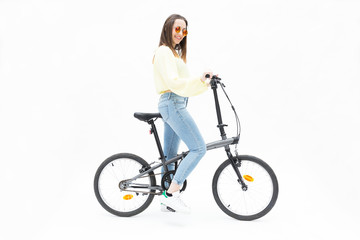 Fototapeta na wymiar Smiling young girl on collapsible bike