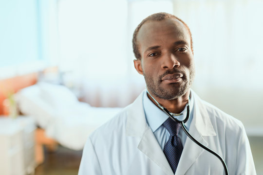 Portrait Of Serious Doctor With Stethoscope Standing In Hospital Chamber