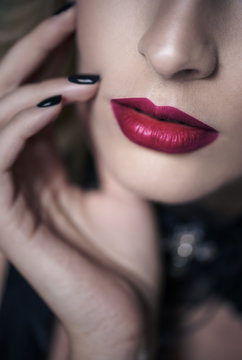 Part of woman red lips and hand on chin