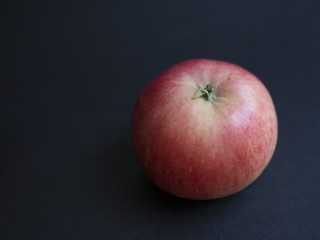 Fototapeta na wymiar Fresh Danish autumn apple (Discovery) isolated on black background