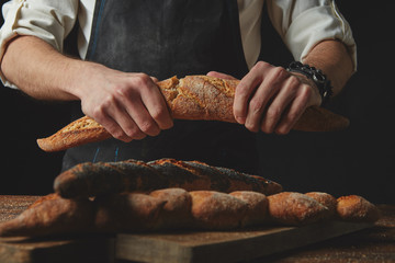Hand breaks baguette