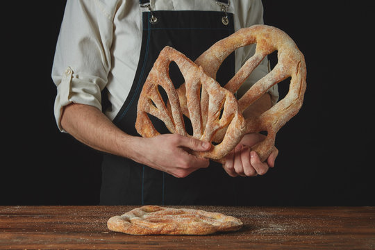 baker is holding fougas bread