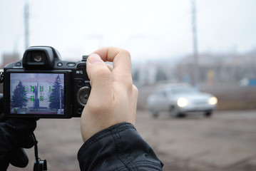A camera in the hands of a photographer takes pictures from afar