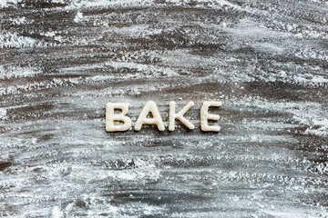top view of word bake made from cookie dough with flour on wooden surface