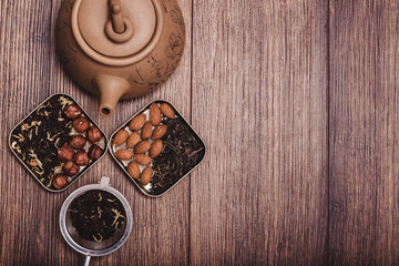 Tea strainer with tea on a wooden surface. Green and black tea Top view with copy space