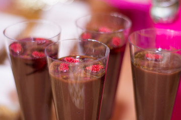 Chocolate pudding with raspberries in glass.
