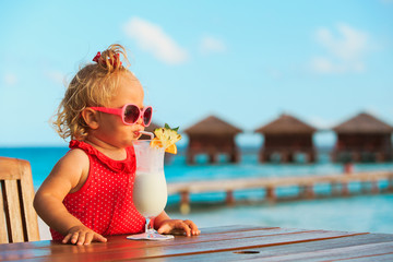 little girl drinking cocktail on tropical beach
