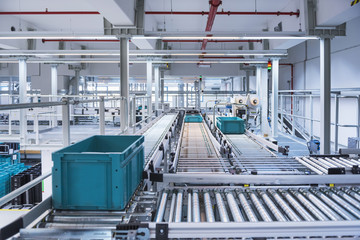 Boxes on conveyor belt in modern automatized high rack warehouse