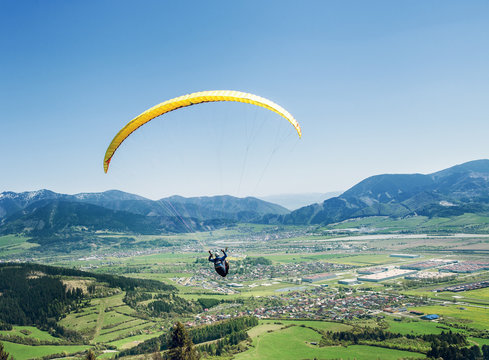 Air sportsman fly on paraplane over the mountain valley
